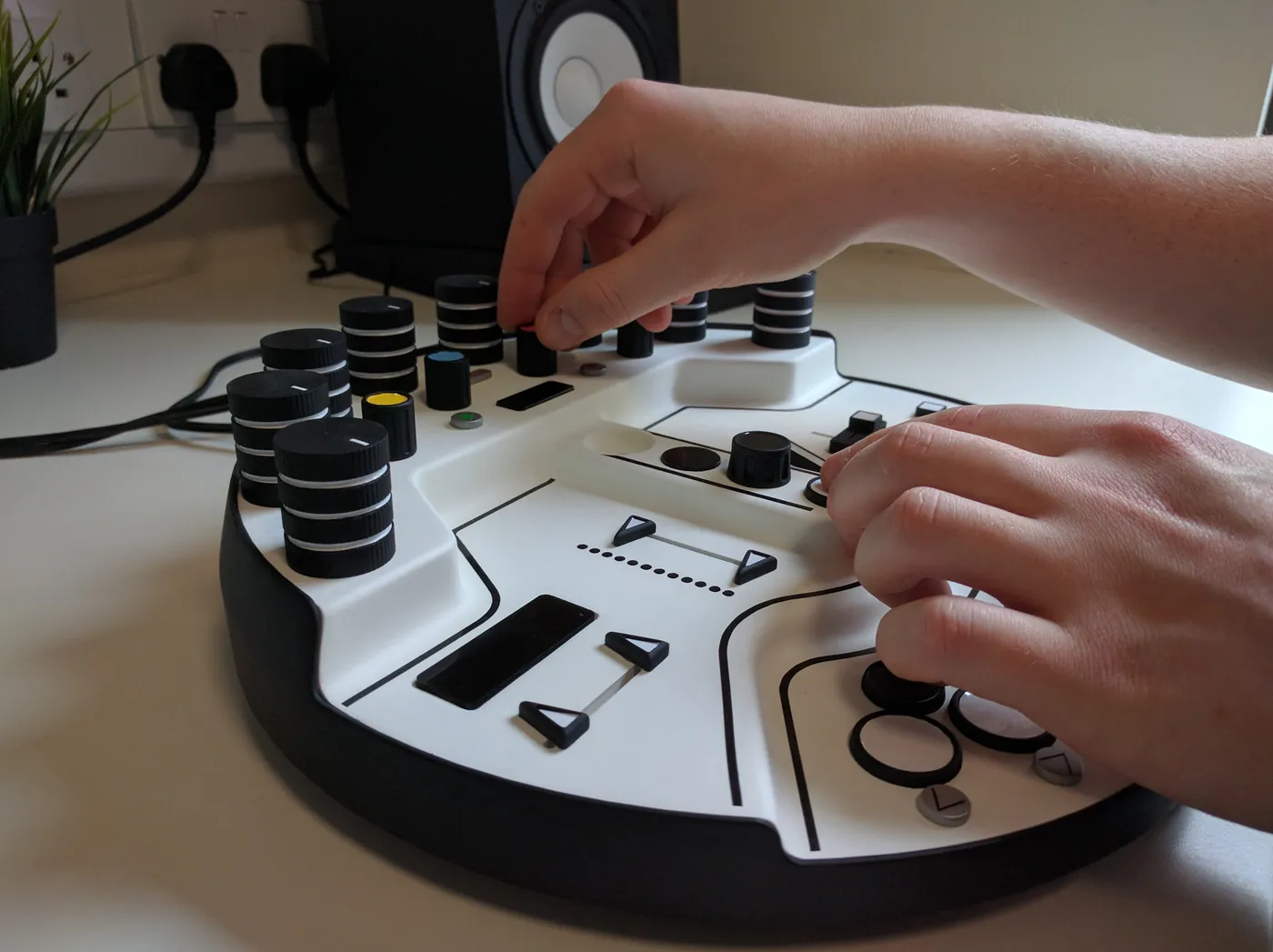 Hands using the Looop visual prototype on a desk between two studio monitors.