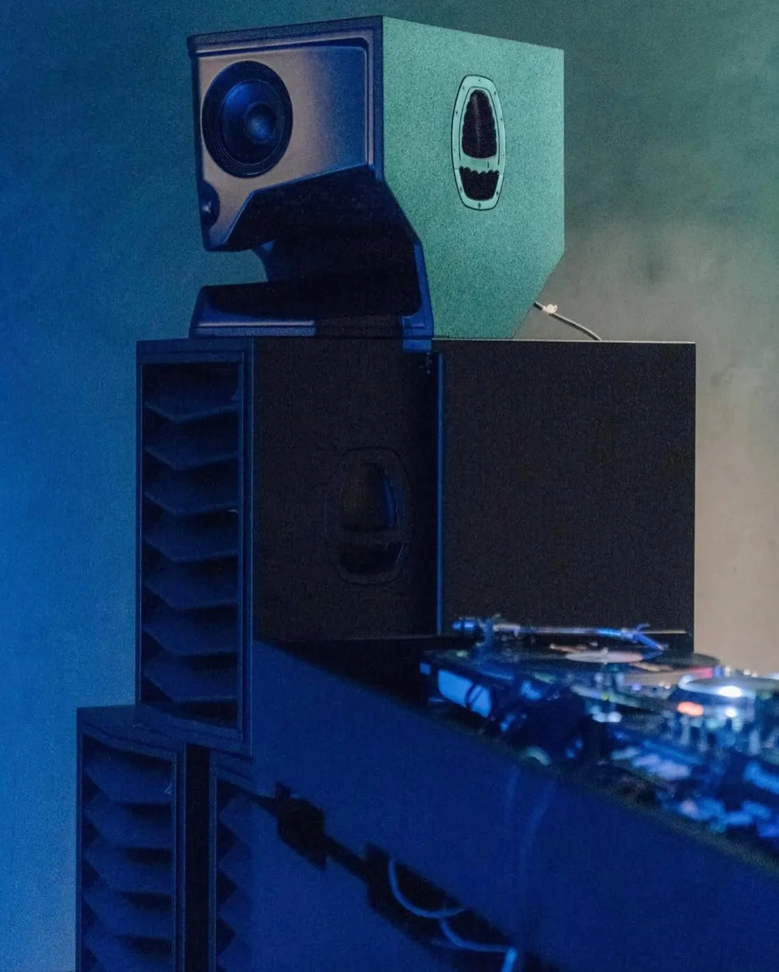 Type. MFR beside the DJ decks at Beam Cube in blue light: the horn module above the slatted cabinet.