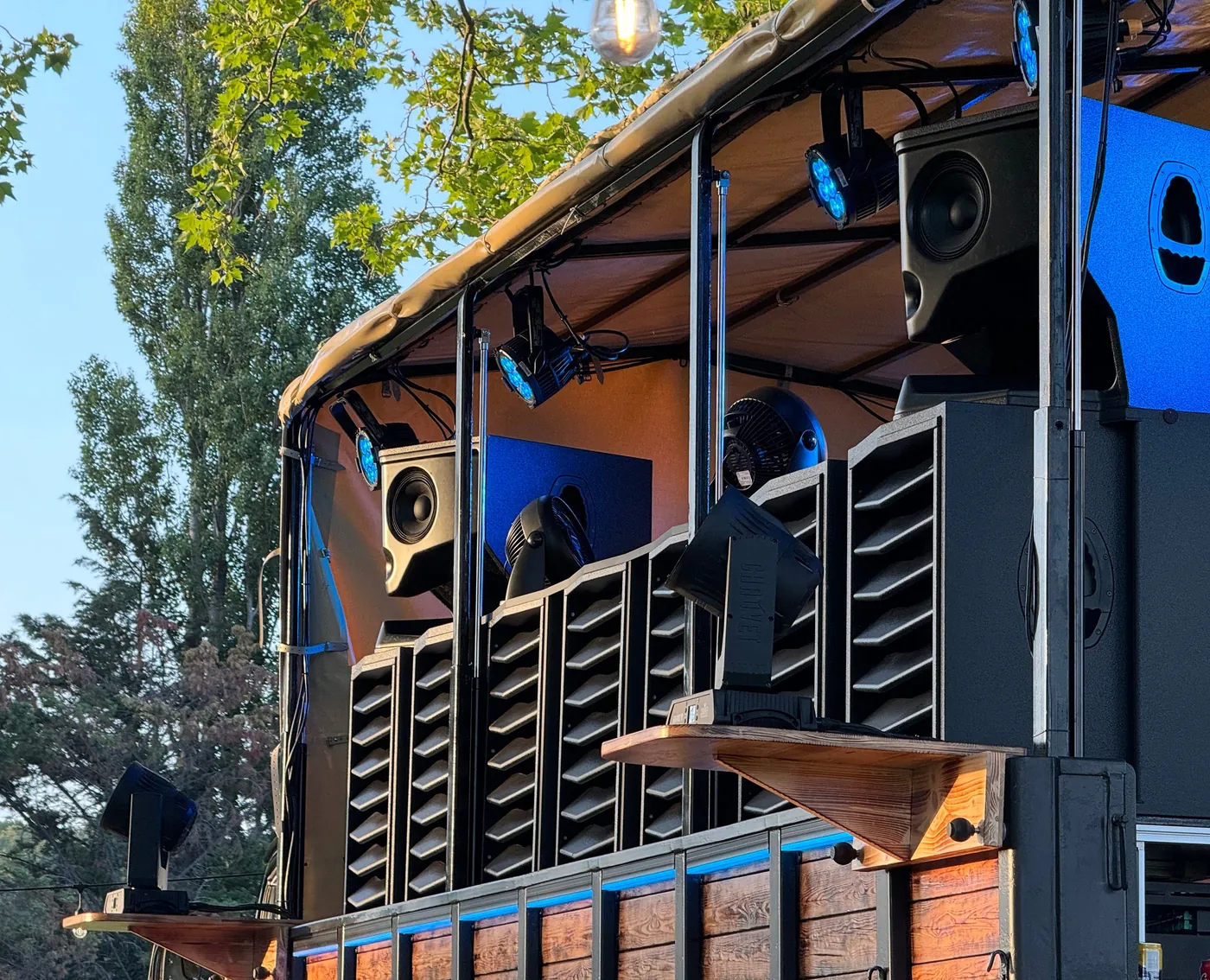 Type. MFR loudspeakers built into the back of a converted 1965 Mercedes truck at Cometogether: horns above tall slatted cabinets, under a canopy.