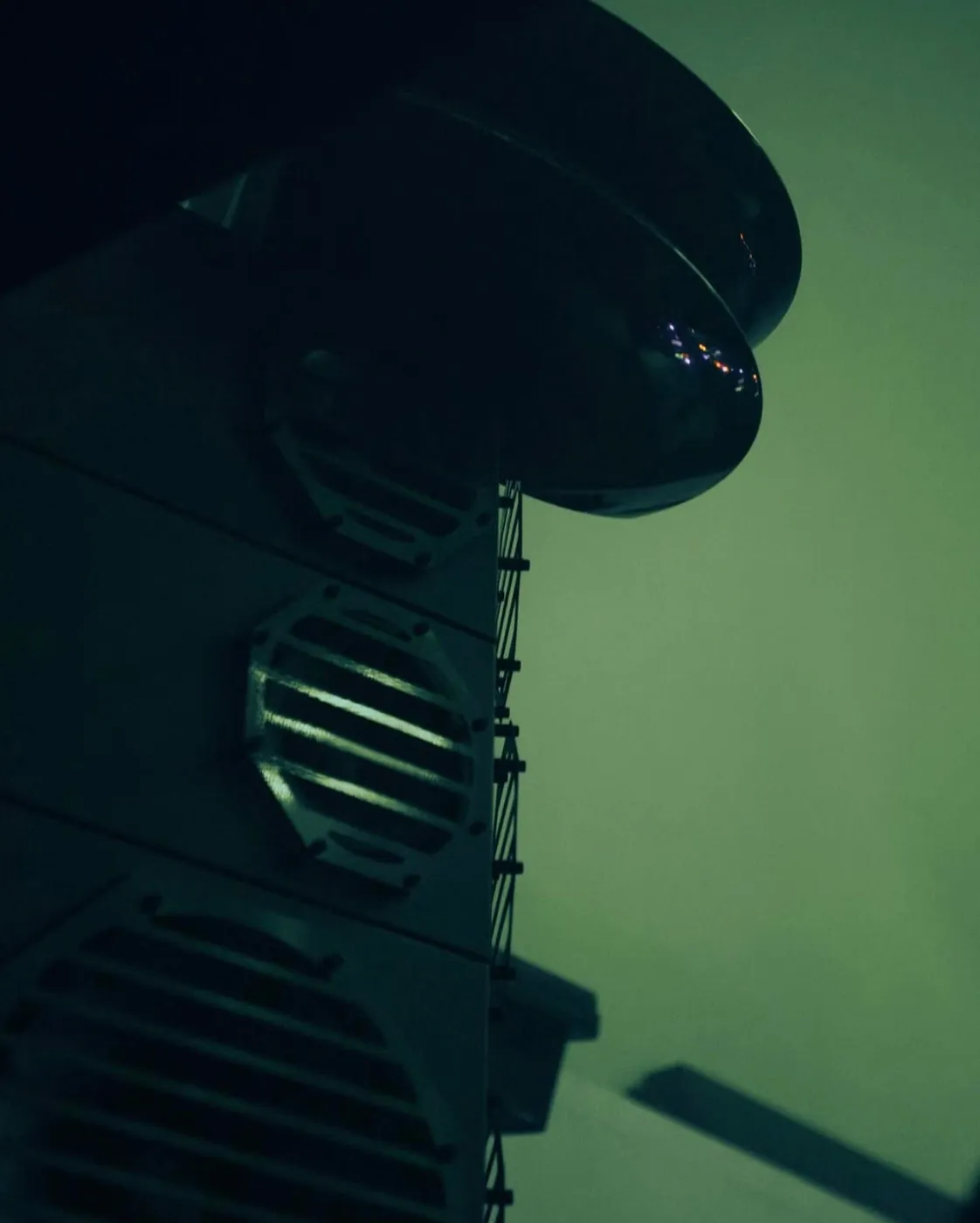 The top of a TOTEM 2 stack at Beam in green light: the horn on top and the octagonal grilles of the modules below.