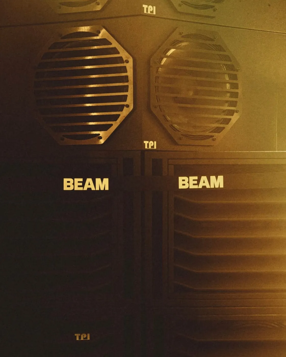 Close-up of TOTEM 2 modules at Beam: octagonal grilles above slatted cabinets, the club's name in gold and TPI logos on the black cabinets.