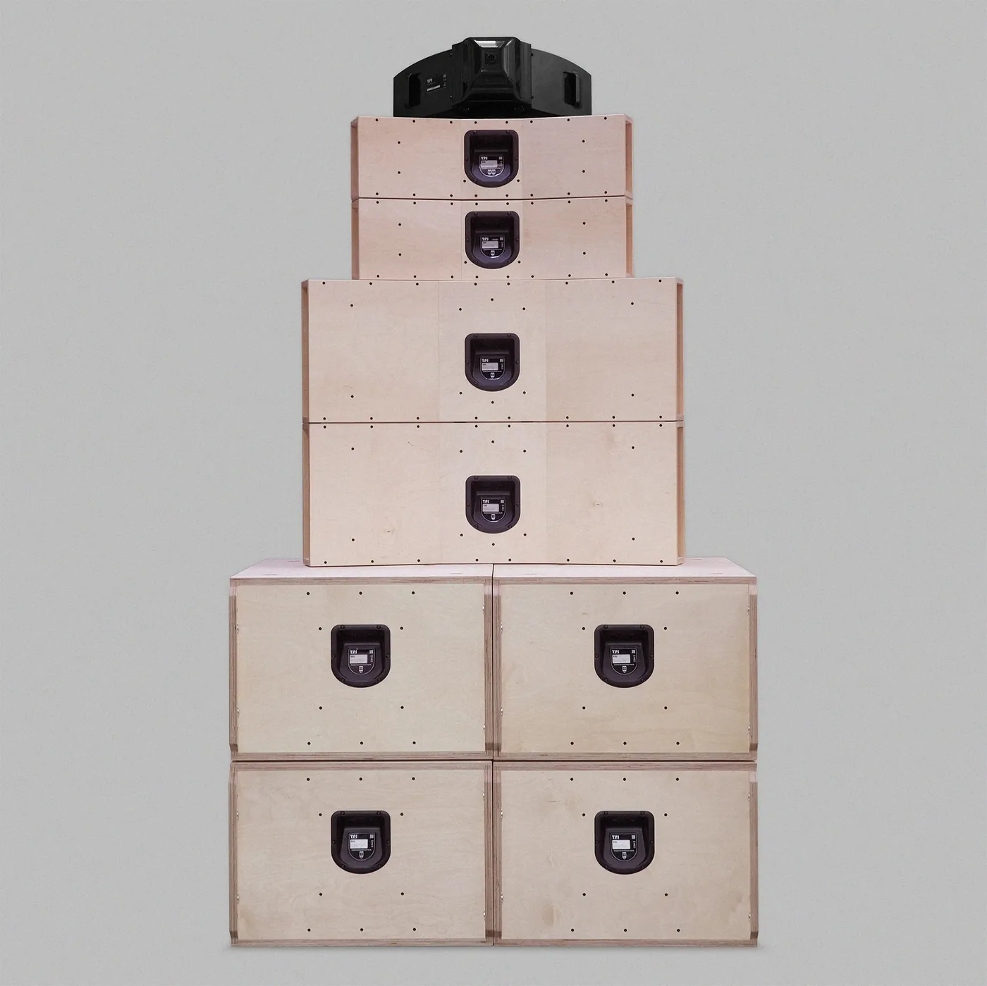 The back of Type. TOTEM 2: plain birch-ply cabinets, each with a black recessed connector dish, stacked two by two at the base and narrowing to the black horn on top.