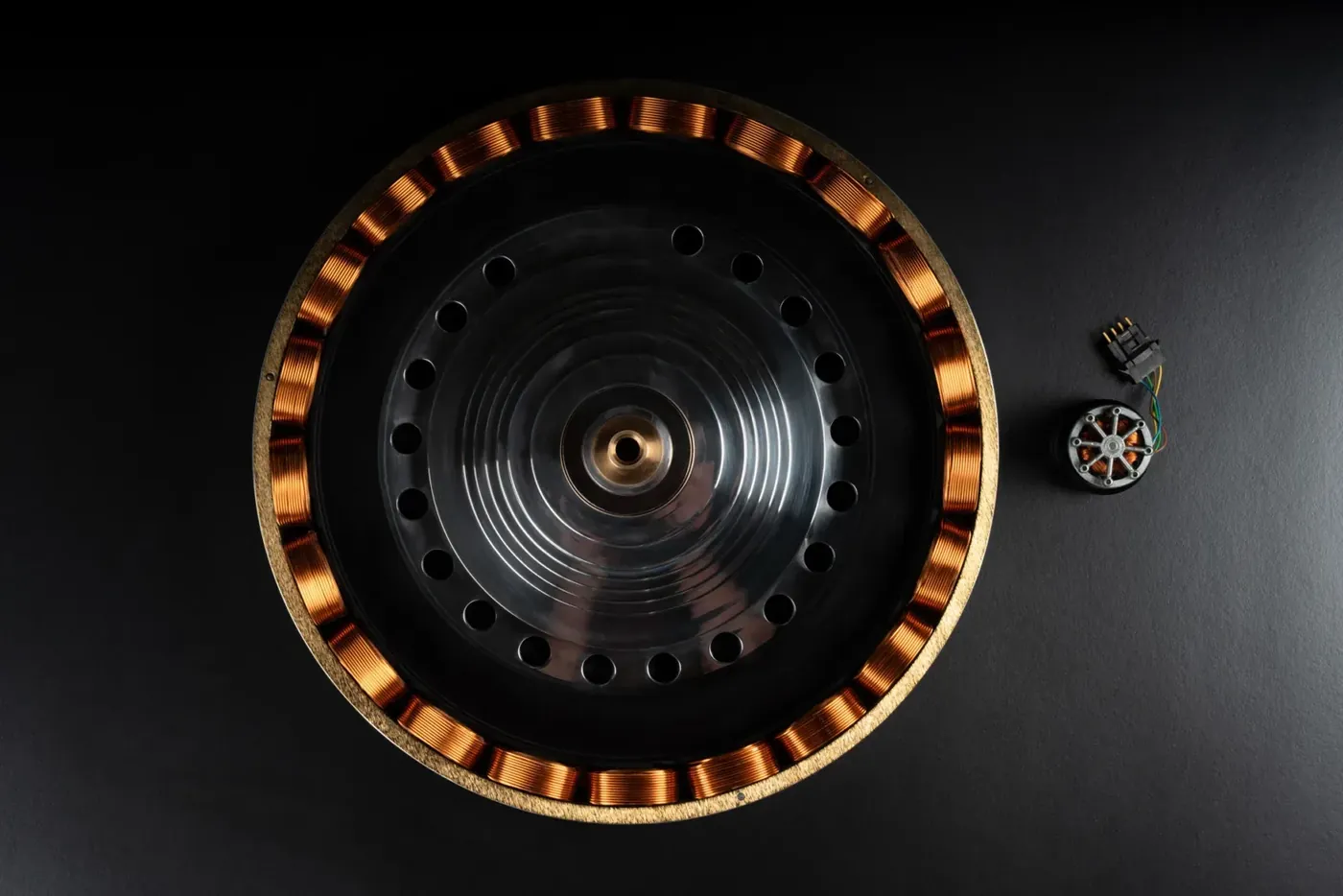 Close-up of the GMT One drive: a ring of copper coils around a machined platter bearing.